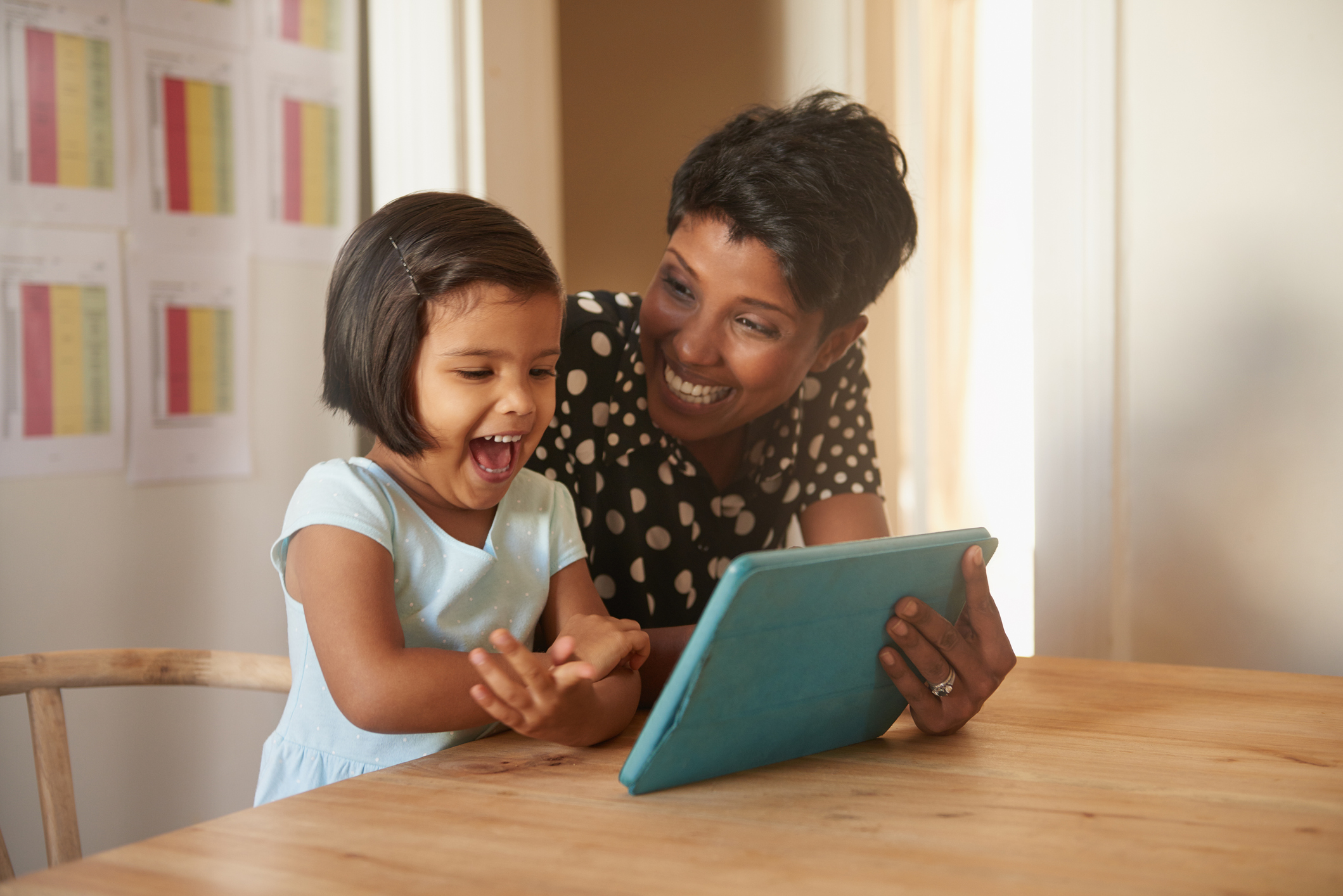 Mother and daughter smiling while exploring Prodigy Core features on their tablet.