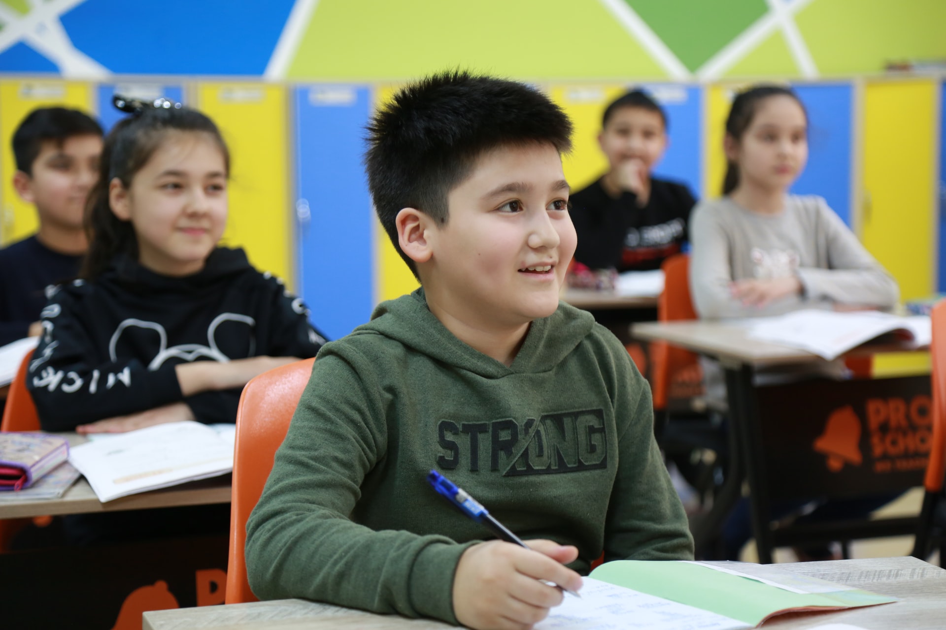 Boy writes in the classroom during a lesson aligned to Bloom