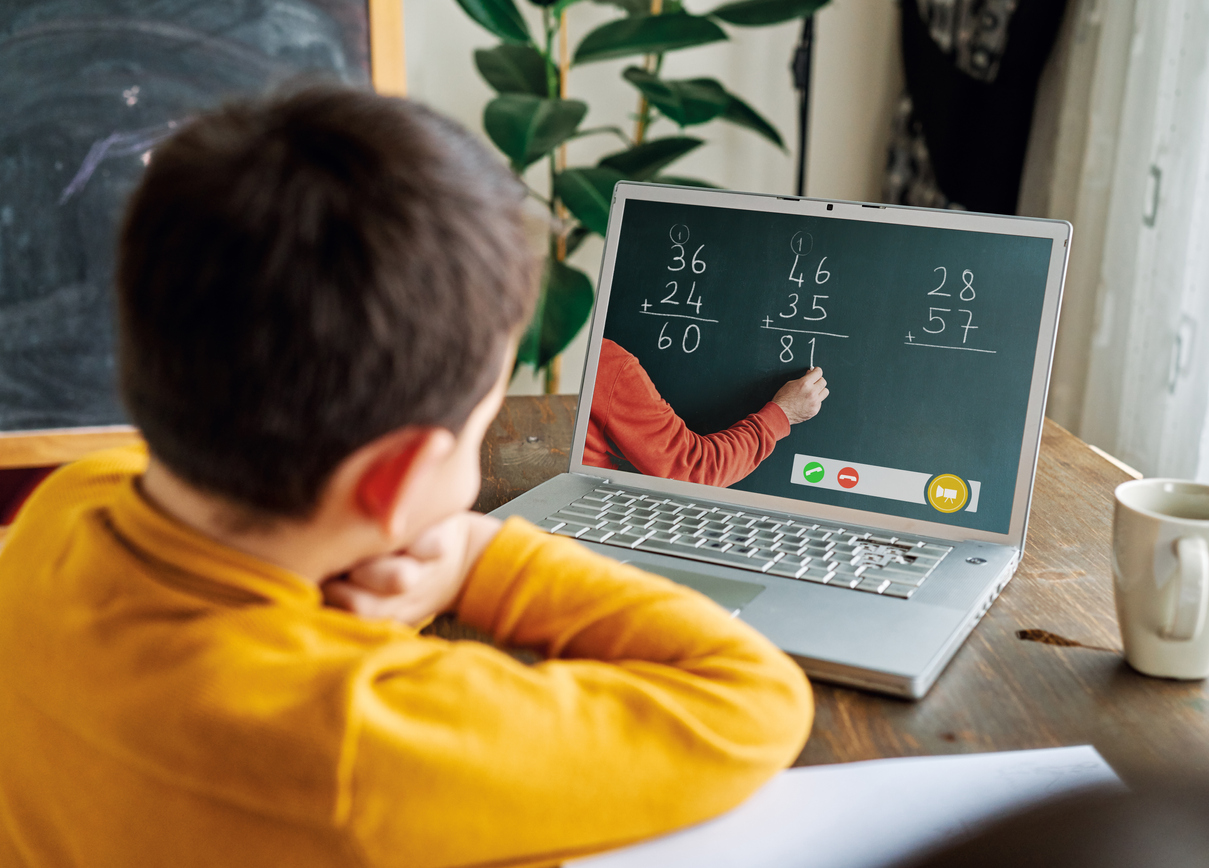 A young boy watching a math lesson on his laptop.