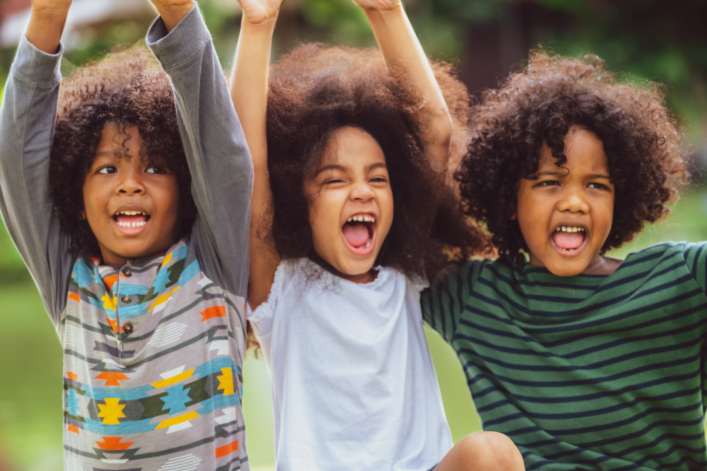 Three happy kids cheer while having fun. 