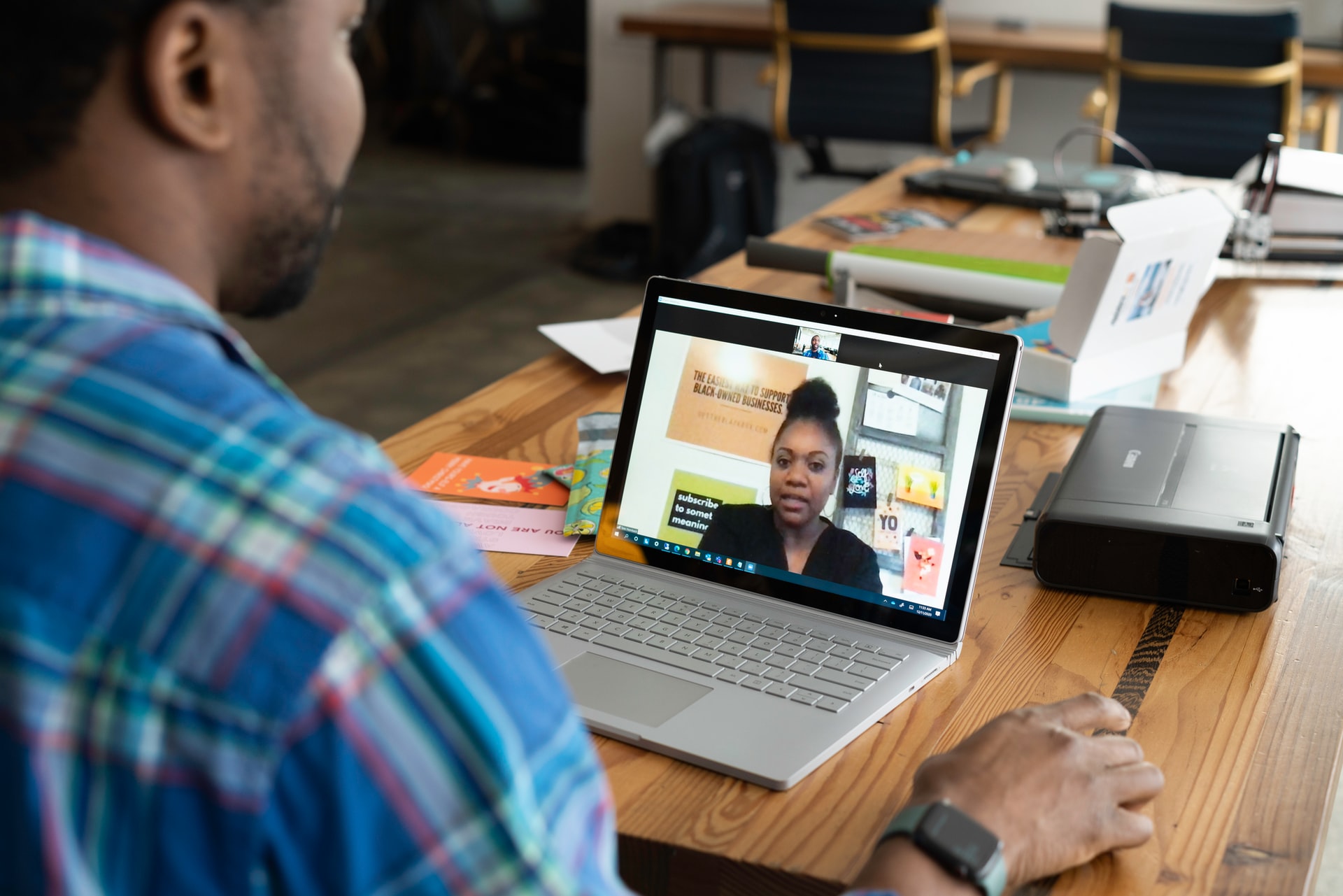 Man talks to a woman on a computer screen using an online learning platform.