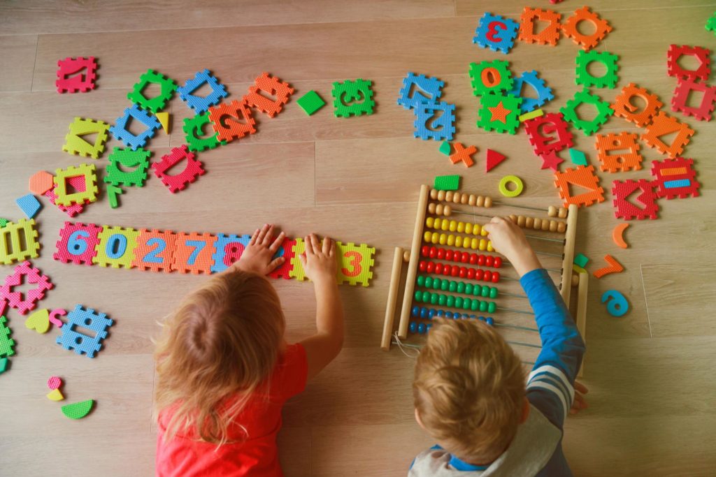 Children practicing motor skills with math manipulatives.