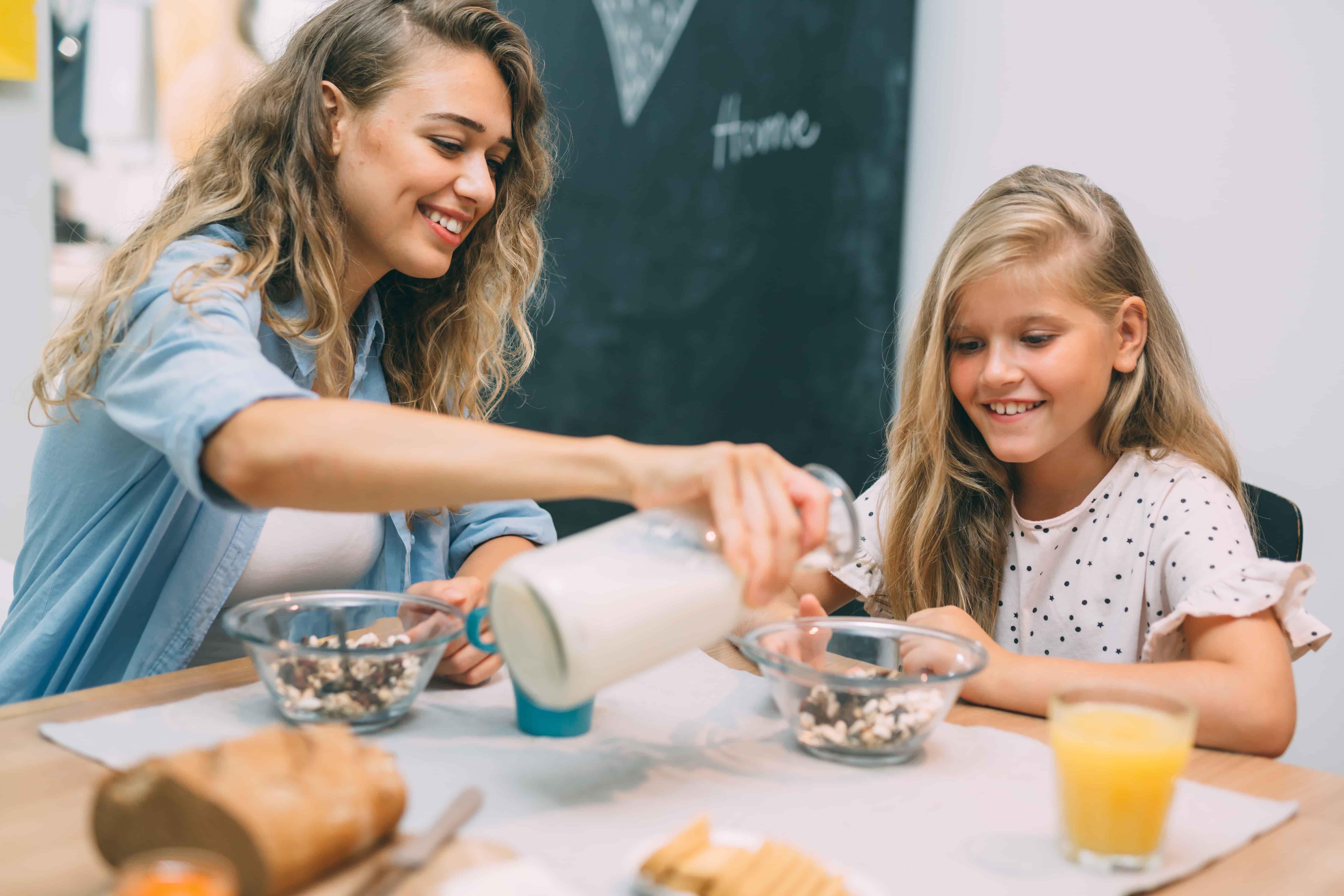 Mom eats breakfast with her daughter.