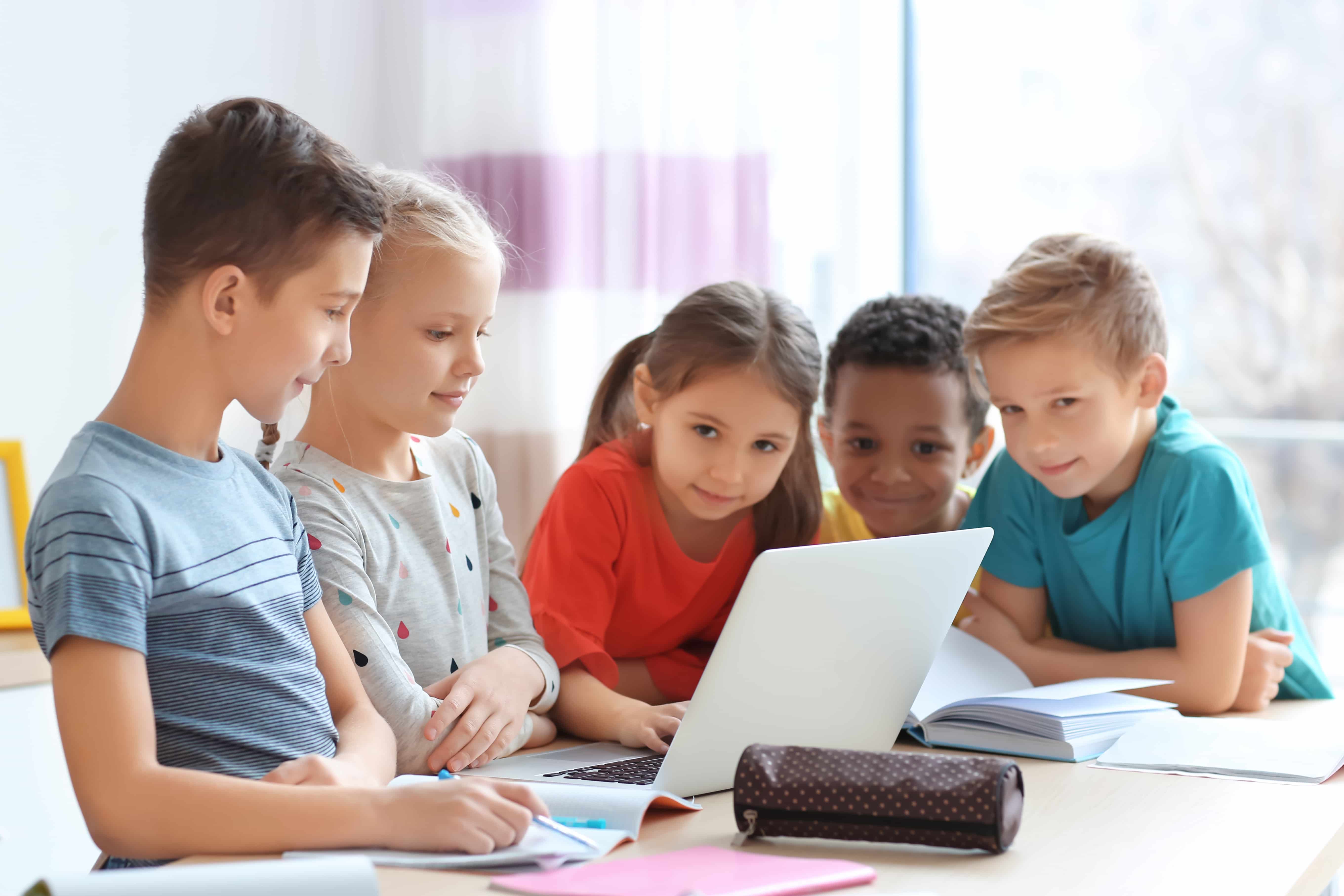 A group of kids using a computer for gameschooling.