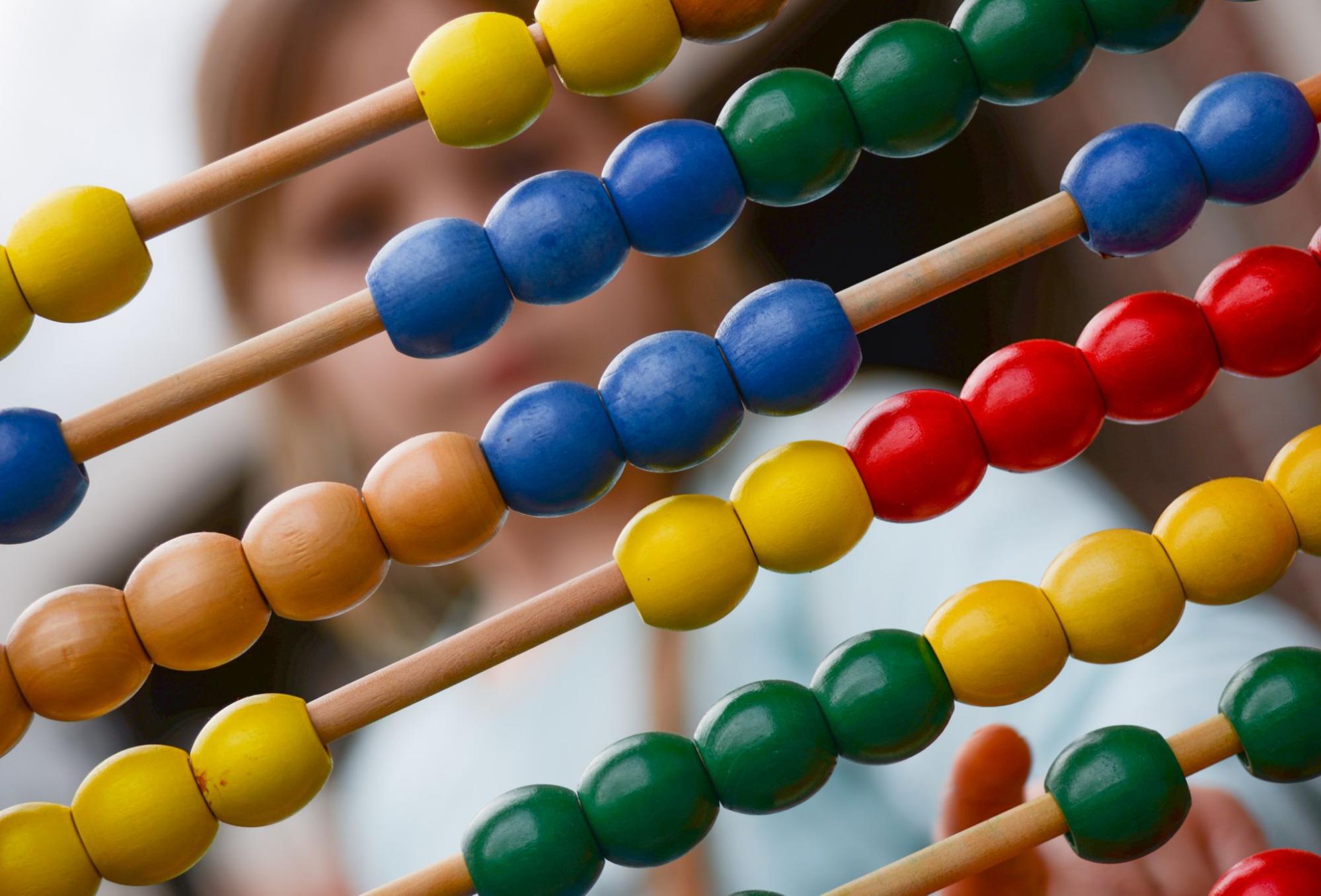 Child uses an abacus during division activities