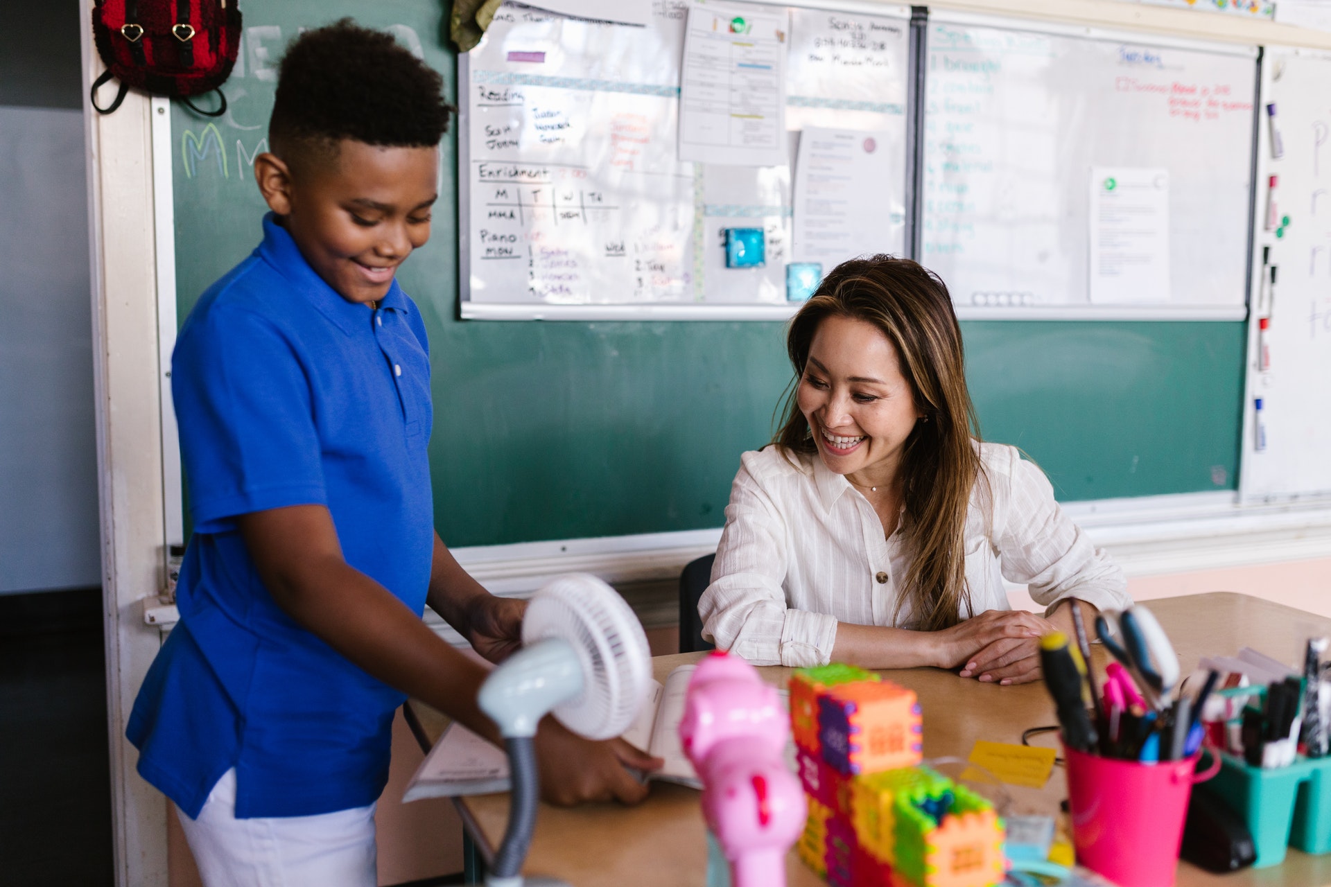 Young student shows his teacher his division work.