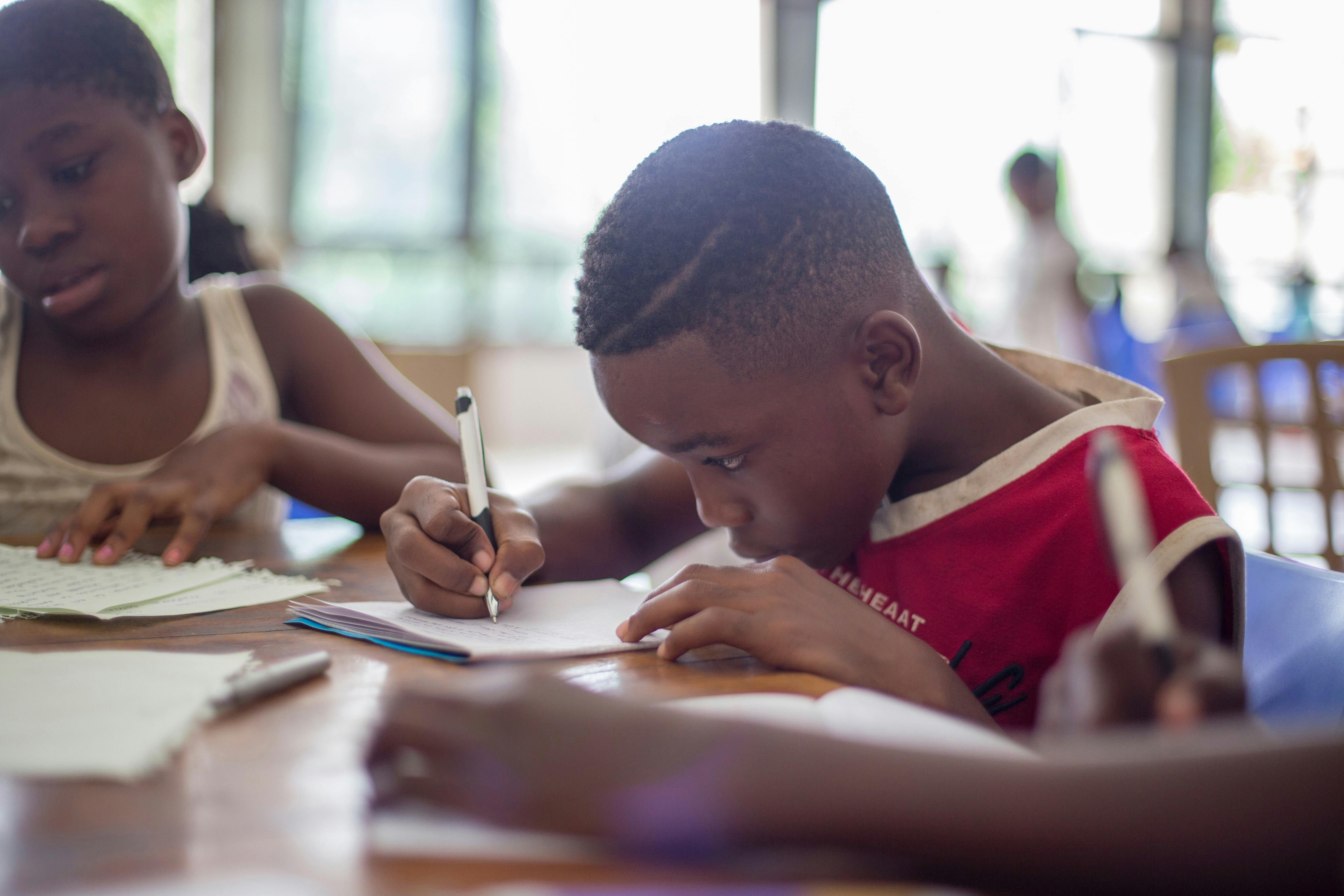 A young boy journaling to practice his writing.