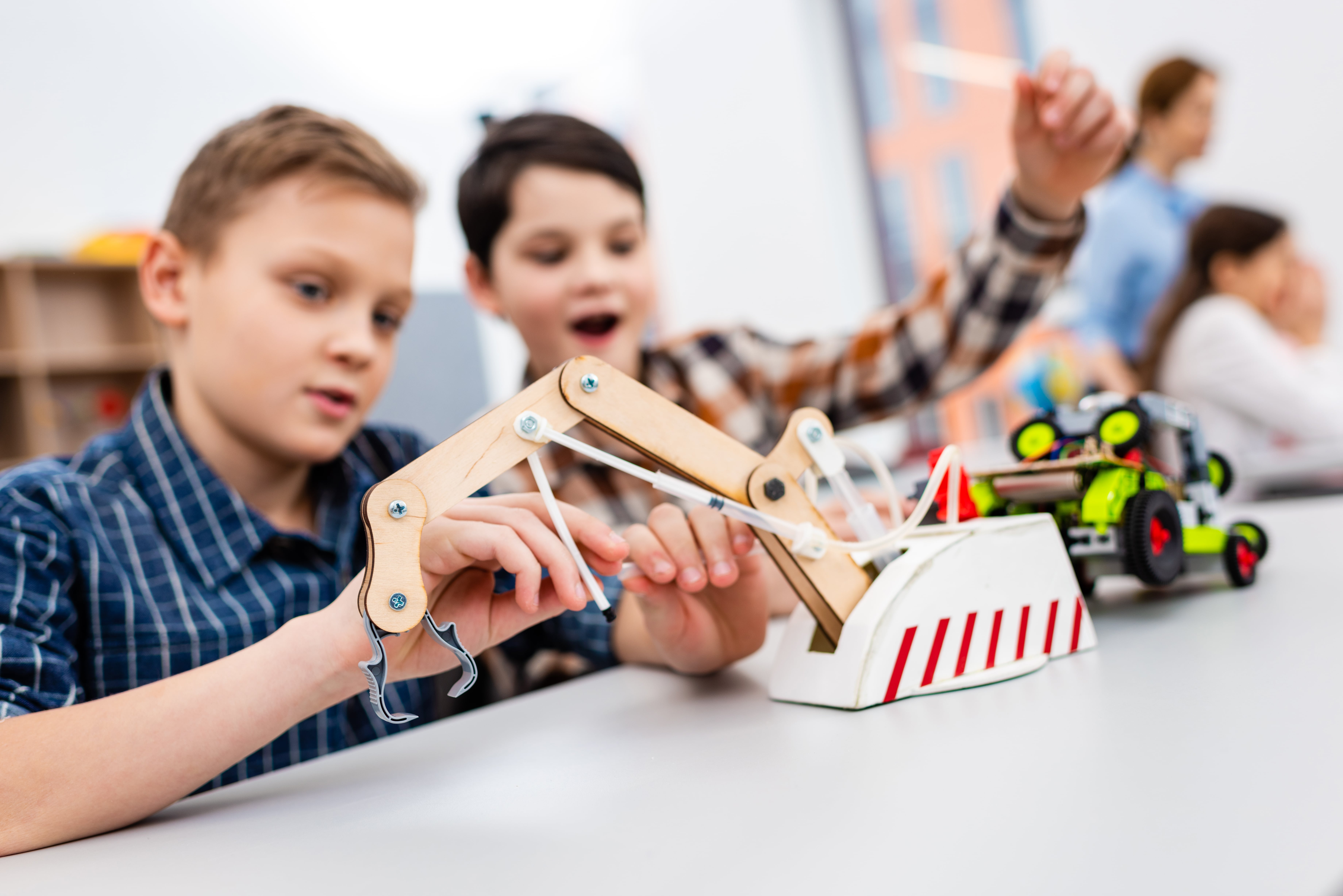 Pupils sitting at desk with educational toys during lesson in classroom